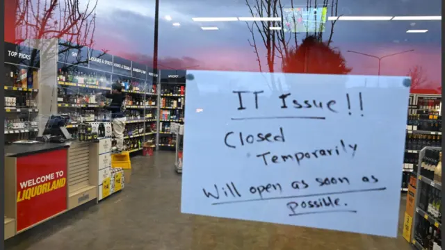 Uma placa notifica os clientes sobre um fechamento temporário devido a problemas de tecnologia em uma loja em Canberra, na Austrália